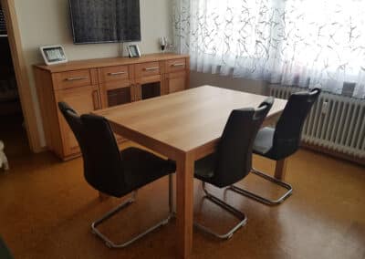 Holztisch mit schwarzen Stühlen